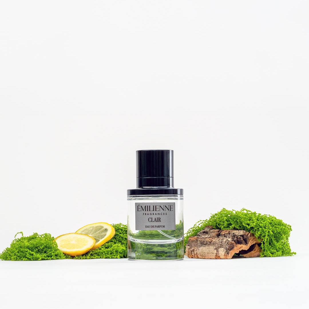Perfume bottle labeled 'Ambre' with a lemon and moss on a white background