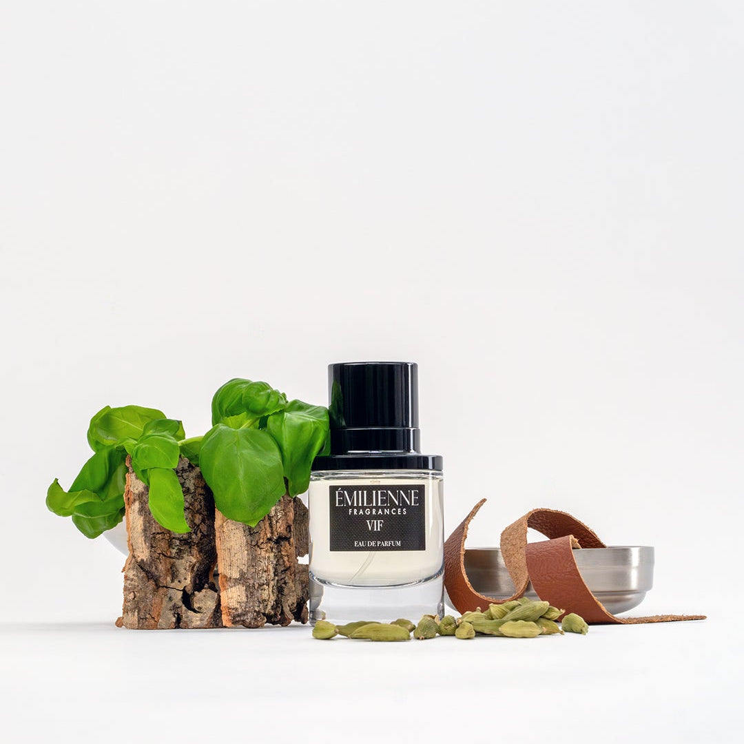 Perfume bottle with green leaves and a small bowl on a white background
