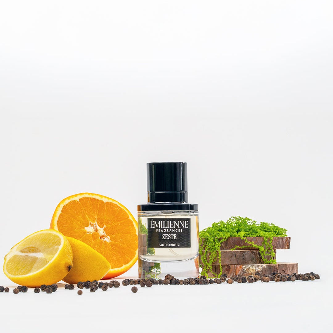 Bottle of Emileene Aromes with citrus fruits and a small house model on a white background